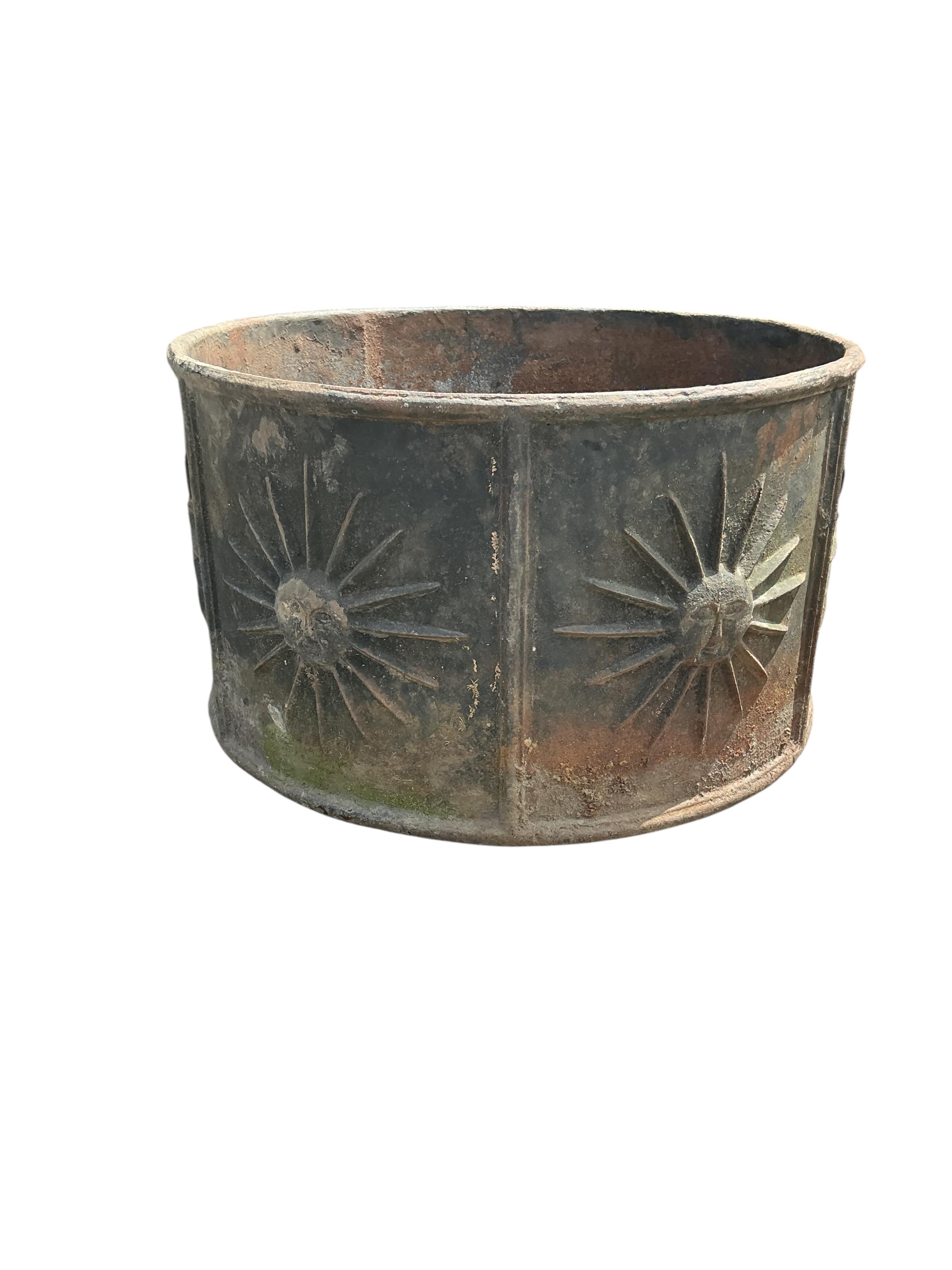 A pair of circular iron planters with cast relief sunburst panels, diameter 52cm, height 30cm